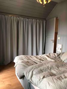 a bedroom with a bed with a curtain and a chandelier at Sommerparadis på Nesbru - 5 min å gå til stranden in Asker