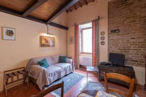 a living room with a couch and a tv at Appartamento Le Rondini in San Gimignano