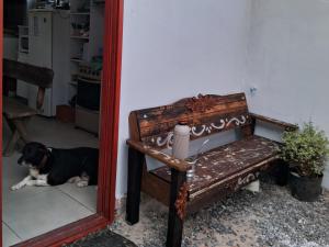 un perro tirado en el suelo junto a un banco en Pousada Luz Beira mar en Tramandaí