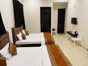 a hotel room with two beds and a television at Goroomgo Banaras Homestay Varanasi Near Ganga Ghat in Varanasi