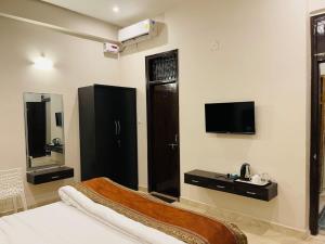 a bedroom with a bed and a tv and a sink at Goroomgo Banaras Homestay Varanasi Near Ganga Ghat in Varanasi