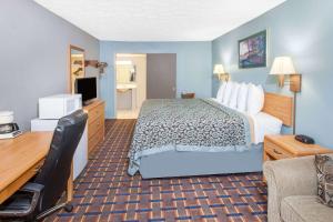 Pokój hotelowy z łóżkiem i biurkiem w obiekcie Days Inn by Wyndham Farmer City w mieście Farmer City