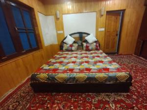 a bedroom with a bed with a quilt on it at Sheraz Guest House , Tangmarg in Tangmarg