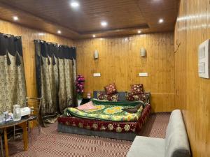 a room with a bed and a couch and a table at Sheraz Guest House , Tangmarg in Tangmarg