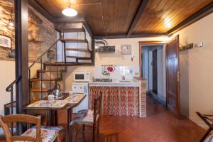 サン・ジミニャーノにあるAppartamento Le Rondiniのキッチン(階段付)、キッチン(テーブル付)