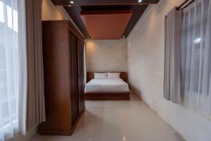 a small bedroom with a bed and a window at Tebluess Gianyar in Bedahulu