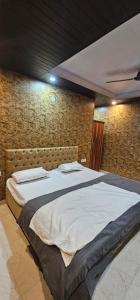 a large bed in a room with a brick wall at Hotel Mussoorie Gold Mary in Mussoorie