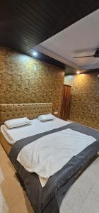 馬蘇里的住宿－Hotel Mussoorie Gold Mary，砖墙客房内的一张大床