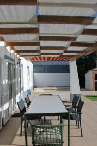 a table and chairs under awning on a patio at Canto do Vale in Aljezur