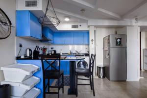 a kitchen with blue cabinets and a refrigerator at City Haven 1br Loft Remote Work, Projector Tv in Dubai