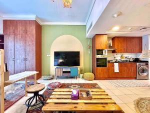 迪拜Rustic Elegance By The Lake Studio Cabin In Jlt的带桌子的客厅和厨房