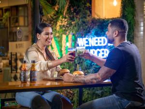 a man and a woman sitting at a table with drinks at Mercure Sao Paulo Berrini in Sao Paulo