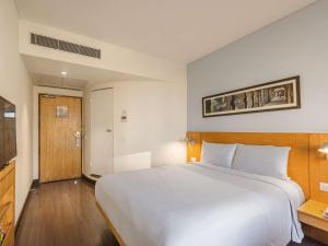 1 dormitorio con 1 cama blanca grande en una habitación en ibis Gurgaon Golf Course Road - An Accor Brand, en Gurgaon
