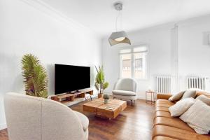 a living room with a couch and a flat screen tv at Hogar Lujoso Centro Zaragoza in Zaragoza