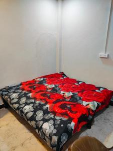 uma cama com um cobertor preto e vermelho em VARDAN PALACE em Ujaim