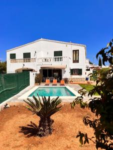 a house with a swimming pool in front of it at Casa a pocos minutos de la playa de Cala Galdana in Cala Galdana
