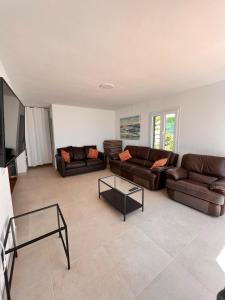 sala de estar con 2 sofás y TV en Casa a pocos minutos de la playa de Cala Galdana, en Cala Galdana