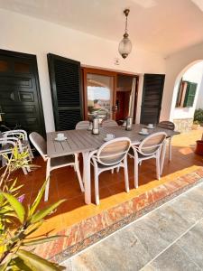 una mesa de madera y sillas en un patio en Casa a pocos minutos de la playa de Cala Galdana, en Cala Galdana