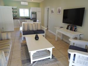 a living room with a couch and a tv at The Dunes Studio 20 in Plettenberg Bay