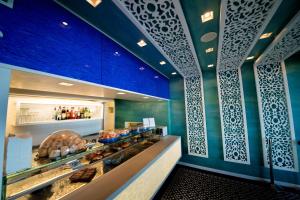 a bakery with blue walls and a counter with pastries at Hotel Oasi Di Kufra in Sabaudia