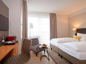 ein Hotelzimmer mit einem Bett, einem Schreibtisch und einem Stuhl in der Unterkunft Mercure Hotel Koeln Belfortstrasse in Köln
