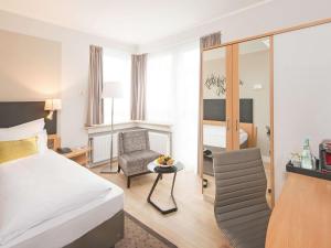 Pokój hotelowy z łóżkiem i krzesłem w obiekcie Mercure Hotel Koeln Belfortstrasse w Kolonii