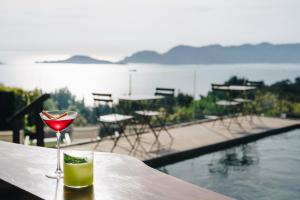 a glass of wine sitting on a table next to a pool at Golfo dei Poeti Relais & Spa in Ameglia