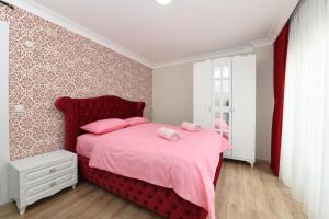 una camera con letto rosso, lenzuola rosa e cuscini rosa di Uzay Suite 2 a Istanbul