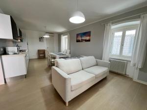 a living room with a white couch and a kitchen at Villa Franca in Grado