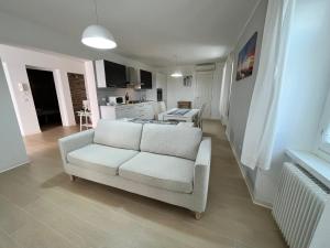 a living room with a white couch and a kitchen at Villa Franca in Grado