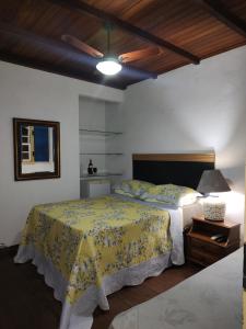 a bedroom with a bed with a yellow bedspread at Antiquário & Pousada da Matriz in Tiradentes