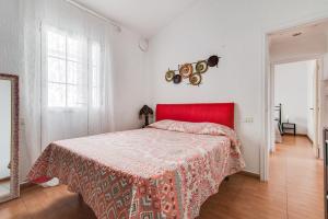 a bedroom with a red bed and a red headboard at Apartamento Buen Hogar in San Bartolomé de Tirajana