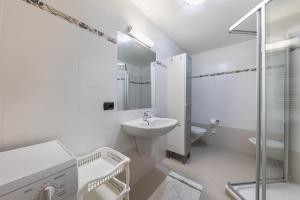 a white bathroom with a sink and a shower at Apartment Litegosa - Casa Alma in Tesero +16 photos