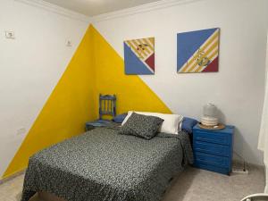 a bedroom with a bed and paintings on the wall at La Buganvilla rooms in Arrecife