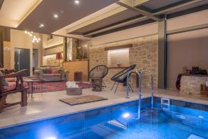 een huis met een zwembad en een woonkamer bij CARPE DIEM HOTEL in Archanes