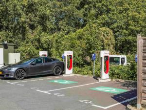 un coche aparcado en un estacionamiento con dos teléfonos públicos en ibis budget Senlis en Senlis