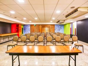 una sala de conferencias con una mesa grande y sillas en ibis budget Rio de Janeiro Nova America, en Río de Janeiro