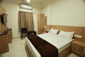 ein Schlafzimmer mit großem Bett und Fernseher in der Unterkunft Slice of Heaven in Mundakāyam