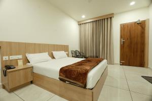 ein Schlafzimmer mit einem großen Bett mit einem hölzernen Kopfteil in der Unterkunft Slice of Heaven in Mundakāyam