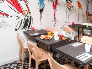 un ristorante con due tavoli e sedie con un piatto di cibo di Ibis Styles Paris Gare Saint Lazare a Parigi