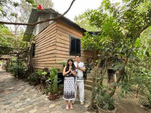 Ein Mann und eine Frau stehen vor einem winzigen Haus in der Unterkunft Sok Phen Homestay in Siem Reap