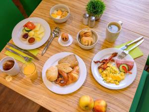a wooden table topped with plates of breakfast food at Ibis Styles Trier City in Trier