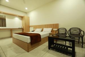 a bedroom with a bed and a table and a chair at Slice of Heaven in Mundakāyam