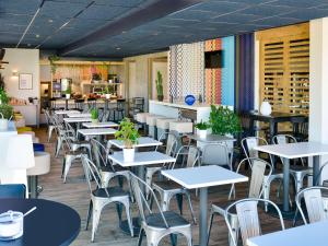 een restaurant met tafels en stoelen en een bar bij ibis Budget Mâcon Crêches in Chaintré