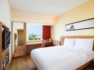 Un dormitorio con una gran cama blanca y una ventana en ibis Hyderabad Hitec City - An Accor Brand en Hyderabad