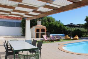 a patio with a table and chairs next to a swimming pool at Canto do Vale in Aljezur