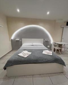 ein Schlafzimmer mit einem großen Bett mit zwei Handtüchern darauf in der Unterkunft Al rifugio di rosmy in Bari