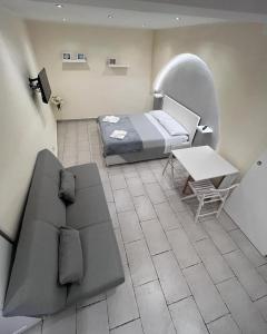 Zimmer mit einem Bett, einem Sofa und einem Tisch in der Unterkunft Al rifugio di rosmy in Bari