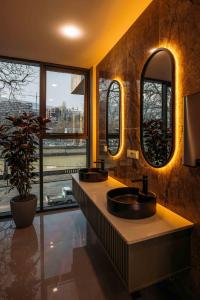 a bathroom with two sinks and a large window at Hotel Monday by DNT Group in Tbilisi City