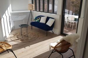 uma sala de estar com uma cadeira azul e uma mesa em Beau T3 avec jardin hyper centre proche gare em Angers